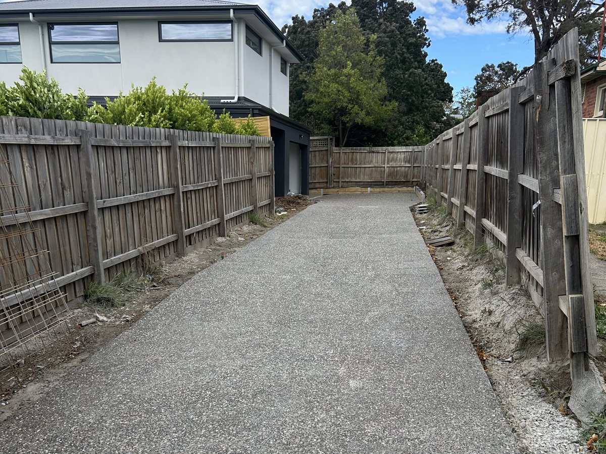 Exposed aggregate driveway running down the side of a block to a rear garage