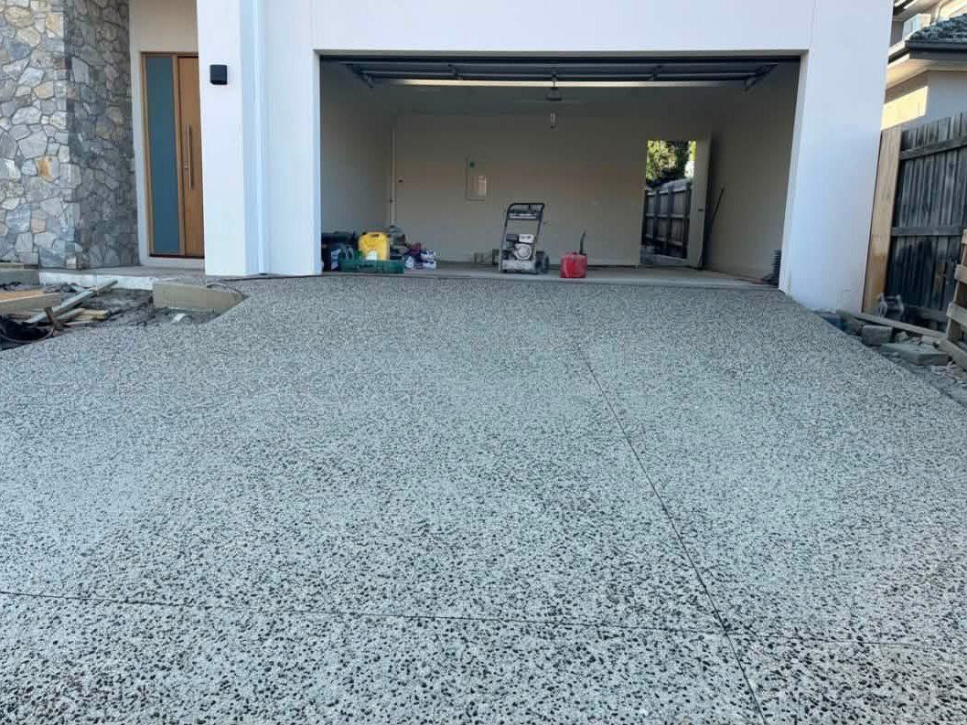 Exposed aggregate driveway and apron running into a garage