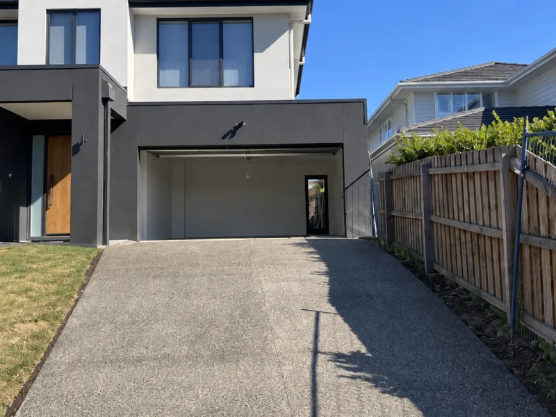 Exposed aggregate driveway leading to the garage of a new home