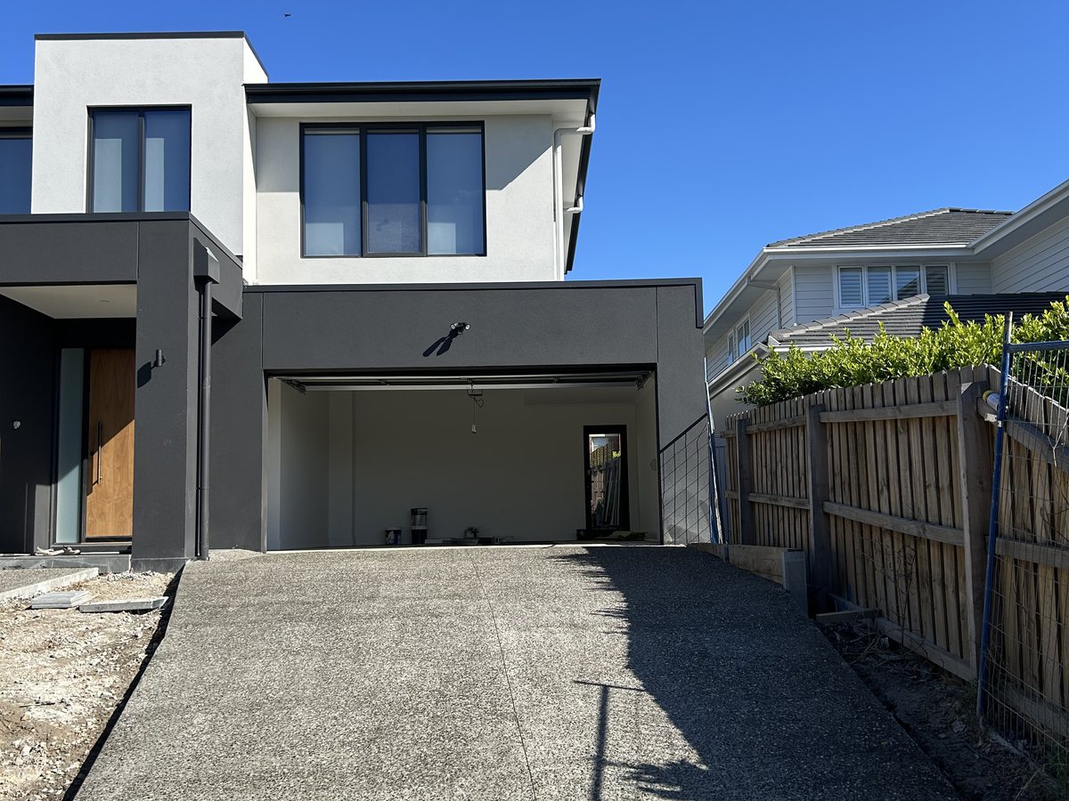 Exposed aggregate driveway running up to the garage of a new two-storey home