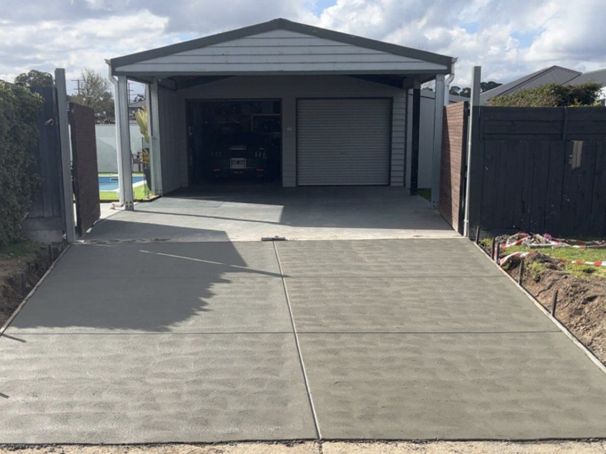 Stipple-finished concrete driveway leading to a double carport