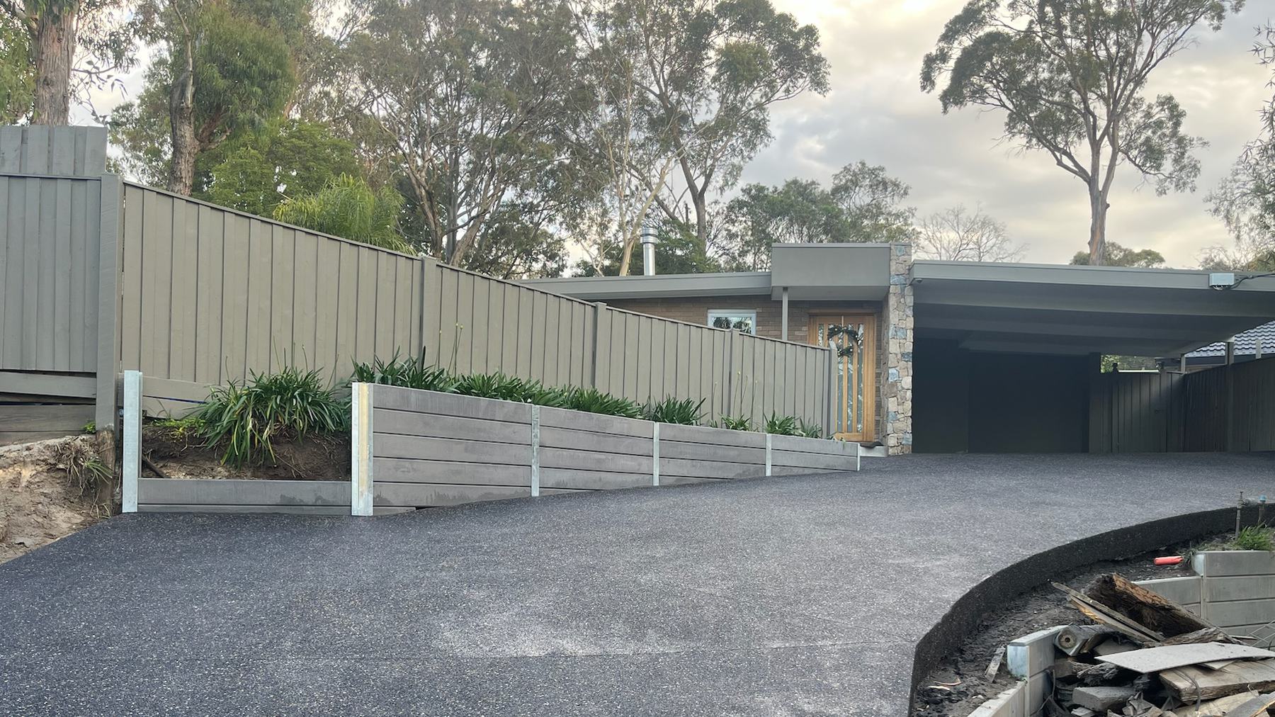 Charcoal exposed aggregate driveway sweeping up to a home in Melbourne's eastern suburbs